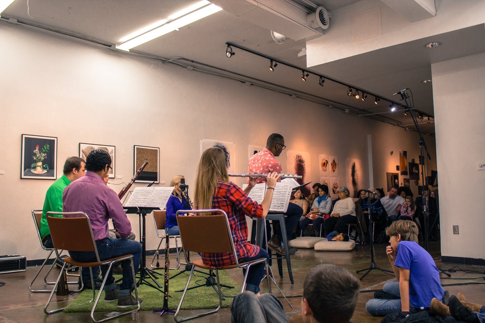 A chamber ensemble performs Peter and the Wolf for a seated audience of families in a gallery space