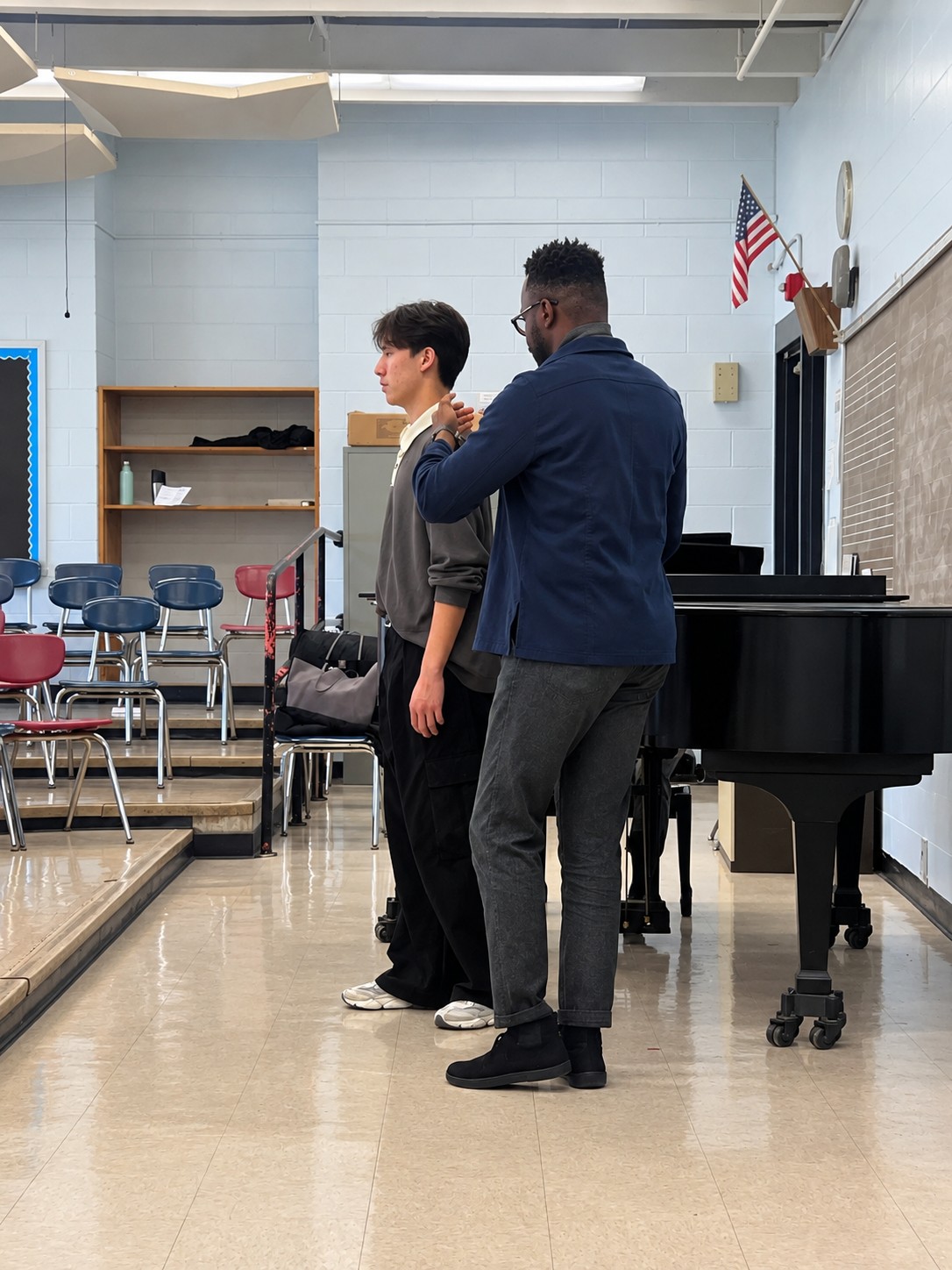 Ty coaching a student's posture at the piano during a voice lesson